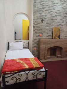 Schlafzimmer mit einem Bett mit einem Spiegel und einem Kamin in der Unterkunft Meramees Hotel in Kairo