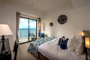 a bedroom with a bed and a large window at Hotel Monterey Okinawa Spa & Resort in Onna