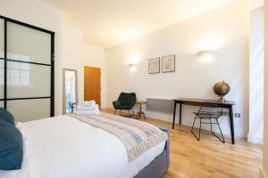 a bedroom with a bed and a desk in it at Wild Roses Serviced Apartments - Angel in London
