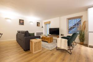 a living room with a couch and a tv at Wild Roses Serviced Apartments - Angel in London