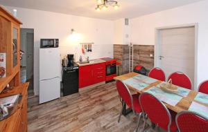 a kitchen with red cabinets and a table with red chairs at 3 Bedroom Pet Friendly Apartment In Eldetal Ot Wredenhagen in Wredenhagen