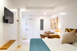 a bedroom with a bed and a tv on a wall at Seaworthy Boracay in Boracay