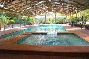 an indoor swimming pool with a pergola at Sanctuary Park Cottages in Healesville