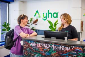 two people standing at a table with a laptop at YHA Hobart Central in Hobart