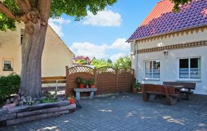 a house with a bench and a fence and a tree at Cozy Apartment In Meiersberg With Kitchen in Meiersberg