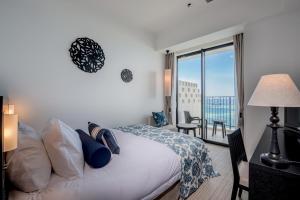 sypialnia z łóżkiem i balkonem z widokiem w obiekcie Hotel Monterey Okinawa Spa & Resort w mieście Onna