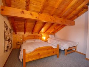 a bedroom with two beds and a wooden ceiling at Chalet Samoëns, 5 pièces, 10 personnes - FR-1-642-3 in Samoëns