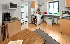 a kitchen with white appliances and a wooden floor at 1 Bedroom Awesome Apartment In Ueckermnde seebad in Neuendorf