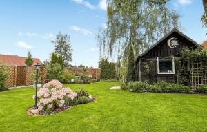 a yard with a house with green grass and flowers at 1 Bedroom Awesome Apartment In Ueckermnde seebad in Neuendorf
