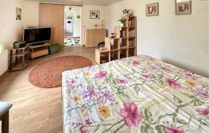 a bedroom with a bed with a floral blanket at 1 Bedroom Awesome Apartment In Ueckermnde seebad in Neuendorf