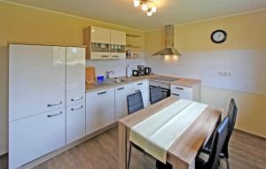 a kitchen with a wooden table and a white refrigerator at 1 Bedroom Cozy Apartment In Mirow in Mirow