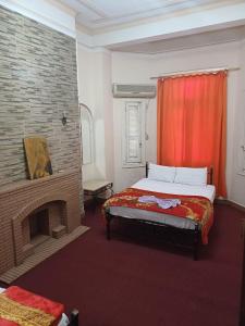 a bedroom with a bed and a fireplace at Meramees Hotel in Cairo