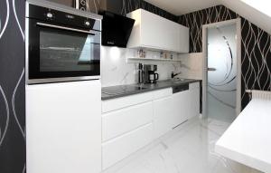 una cocina con armarios blancos y un aparato negro en Beautiful Apartment In Dabel With Lake View en Dabel