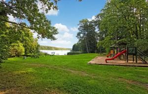 a playground in a park next to a lake at 2 Bedroom Cozy Home In Boitzenburger Land in Rosenow