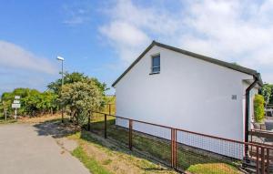 a white building with a fence next to a road at Ferienhaus Gahlkow in Gahlkow