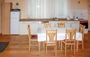 a kitchen with a table and chairs and a kitchen with a sink at Nice Home In Boitzenburger Land Ot With Kitchen in Rosenow