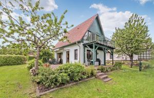 uma pequena casa branca com um telhado verde em Amazing Home In Torgelow Am See With Lake View em Torgelow am See