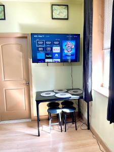 a table with two chairs and a tv on the wall at cozy corner in Philadelphia