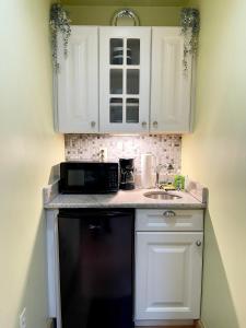 a kitchen with white cabinets and a black dishwasher at cozy corner in Philadelphia