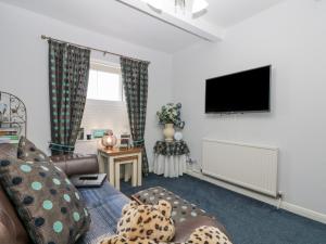a living room with a couch and a flat screen tv at Amari in Scarborough