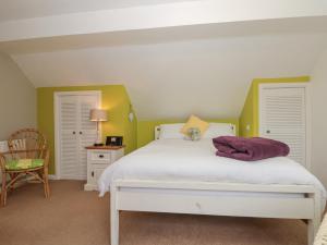 a bedroom with a white bed and a chair at Amari in Scarborough