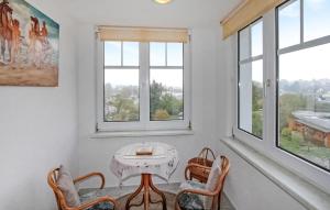 uma mesa e cadeiras num quarto com janelas em Stunning Apartment In Heringsdorf seebad With Kitchen em Bansin