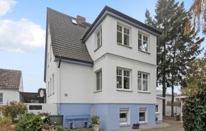 uma casa branca e azul com um telhado preto em Stunning Apartment In Heringsdorf seebad With Kitchen em Bansin