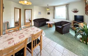 Una sala de estar con una mesa y sillas y un televisor. en Ferienhaus Zinnowitz Seebad, en Zinnowitz