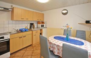 een keuken met een tafel met een vaas met bloemen erop bij Cozy Home In Lubmin seebad With Kitchen in Lubmin