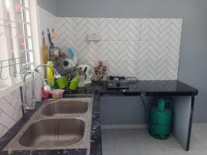 a kitchen with a sink and a counter top at Ria Homestay & kolam in Alor Setar