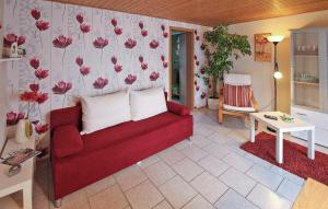 een woonkamer met een rode bank en een tafel bij Amazing Home In Fuhlendorf With Kitchen in Fuhlendorf