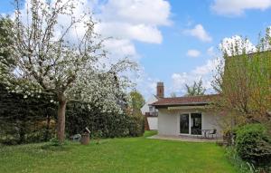 een tuin met een huis en een boom met witte bloemen bij Stunning Home In Knigs Wusterhausen Ot With Wifi in Kablow