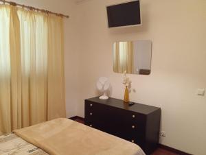 a bedroom with a bed and a dresser with a mirror at Sunrise Holidays in Porto Santo