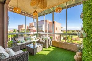 een woonkamer met grote ramen en groen gras bij Luxury Living Flat in Prestigia Marrakech in Marrakesh