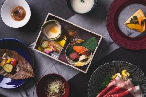 Kamisuwa Onsen Shinyu في سوا: طاولة مع أطباق من الطعام وأوعية من الطعام
