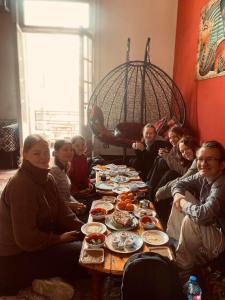 eine Gruppe von Menschen, die an einem Tisch mit Essen sitzen in der Unterkunft Meramees Hotel in Kairo
