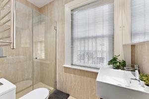 uma casa de banho com um WC, um lavatório e um chuveiro em Beautiful 3BR House Close to Central Station em Sydney
