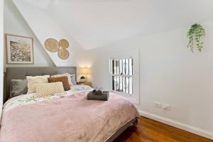 um quarto com uma cama grande e uma janela em Beautiful 3BR House Close to Central Station em Sydney