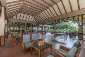 un vestíbulo de un complejo con mesas y sillas en Botany Beach Resort, en Na Jomtien