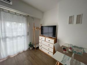 a living room with a television and a dresser with a window at Saint Louis Aparts in Rosario