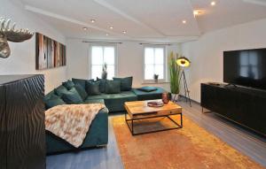 uma sala de estar com um sofá verde e uma televisão em Ferienwohnung Mit Charme em Burg Stargard