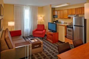 a living room with a couch and a kitchen at TownePlace Suites by Marriott Orlando East/UCF Area in Orlando