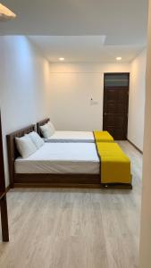 een slaapkamer met een bed met een gele deken erop bij HOMESTAY DARULFALAH -Private Pool in Kuala Terengganu