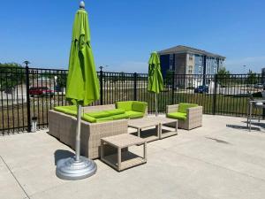 a patio with two chairs and an umbrella and tables at Luxury 1BR/1BA w/ Top Amenities in Prime Location in Fort Wayne