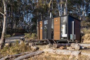 a tiny house sitting on a pile of logs at Wallaby Cabin in Crackenback