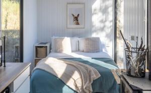 una camera da letto con un letto coperto di Wallaby Cabin a Crackenback