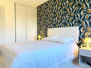 - une chambre avec un lit bleu et un mur à motifs dans l'établissement Appartement Le Lavandou, 3 pièces, 4 personnes - FR-1-251-584, au Lavandou