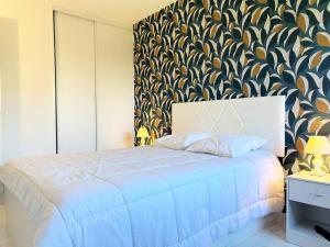 - une chambre avec un lit bleu et un mur à motifs dans l'établissement Appartement 3 pièces refait à neuf avec parking, 4 couchages, proche plage et commerces - Le Lavandou - FR-1-251-584, au Lavandou