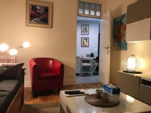 ein Wohnzimmer mit einem Sofa und einem roten Stuhl in der Unterkunft Cosy Home in Paris 15 in Paris
