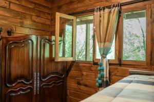 a bedroom with wooden walls and windows and a bed at RUNA YAKU KAUNAZ in Salta